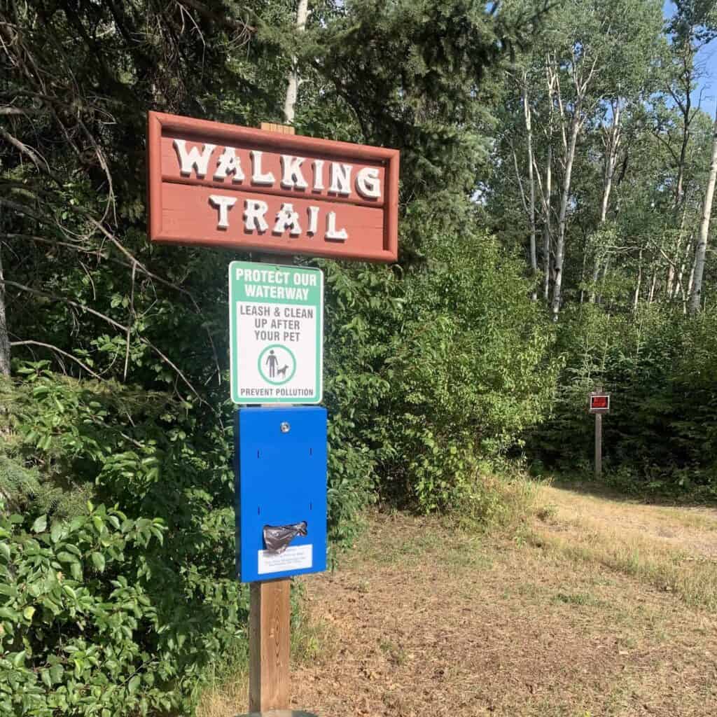 Lake Trail marker with doggie bags and garbage can at Spring Lake Ranch Alberta